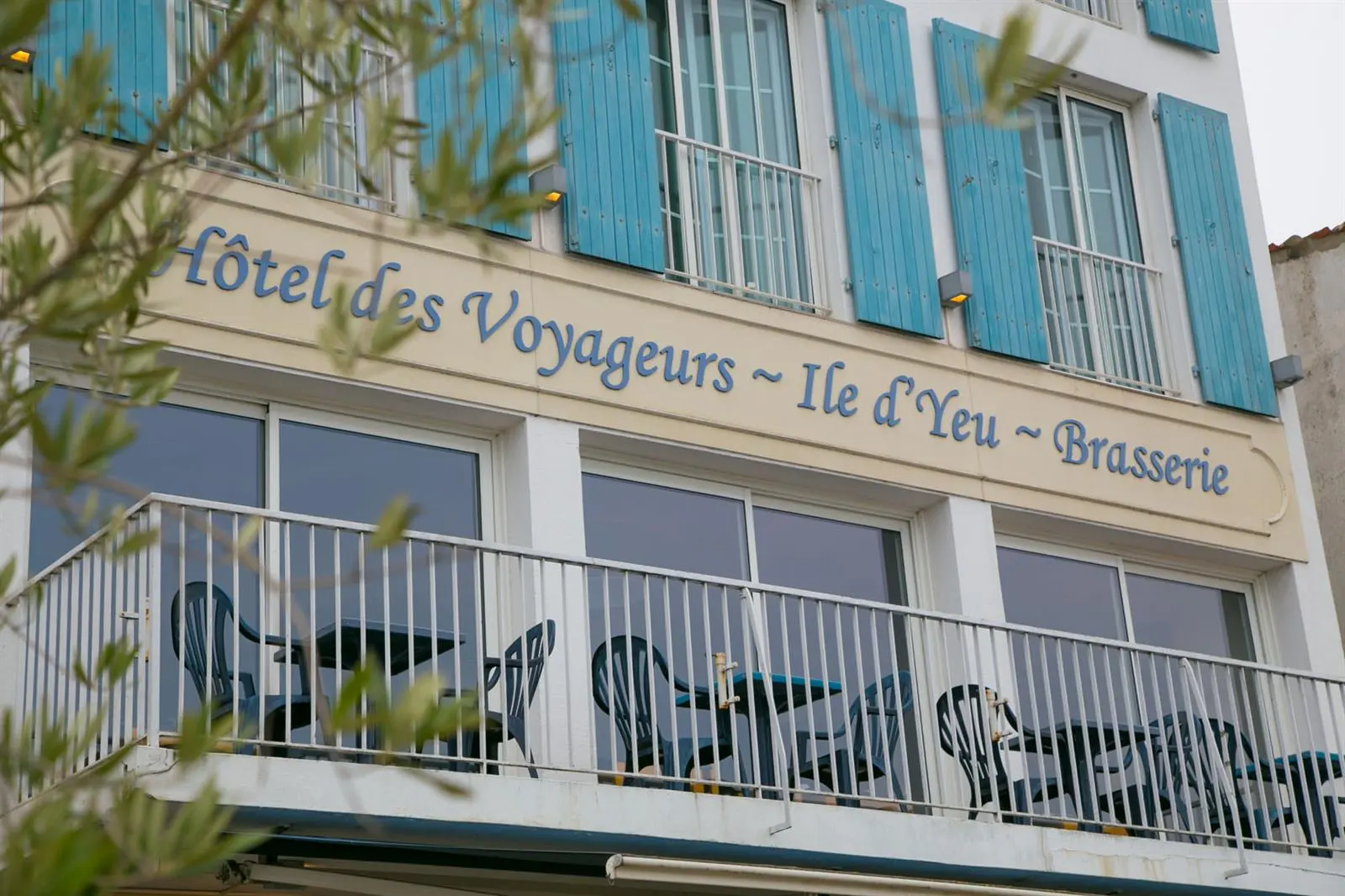 Façade de l'Hôtel des Voyageurs, avec ses volets bleus et son balcon